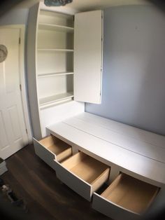 a white cabinet with drawers and shelves in a room