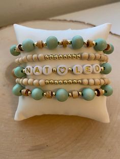 Our 5 stack MINT-TO-BE boho stack! These are super stylish, comfortable and perfect for daily wear! Such a chic boho-look! (These are meant to fit snug. If you would like them to feel loose and move around on your wrist, please size up). Each bracelet is carefully handmade with high quality materials: -8mm natural wood beads (mint color) -4mm natural wood beads -natural wood heishi beads -3mm gold hematite beads -7mm white/gold acrylic letters (other color options available- see pic) -Cord: high Mint Green Wedding, Word Bracelets, Bracelets Wedding, Boho Bracelets Stack, Stacked Beaded Bracelets, Sisters Jewelry, Homemade Bracelets, Healing Stones Jewelry, Wood Bead Bracelet