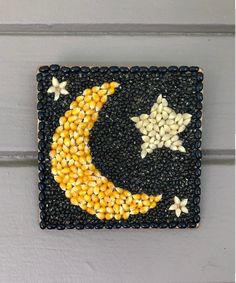 an art piece made out of beads and corn on the side of a door with a star and moon