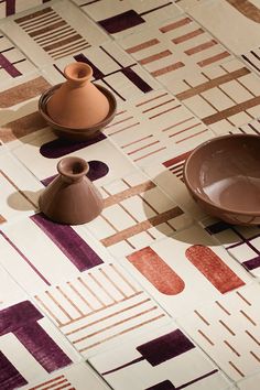 two brown vases sitting next to each other on top of a floor covered in tiles