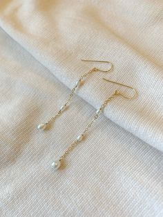 These delicate genuine pearl earrings add an elegant hint of shimmer to your special occasion look! The dainty and minimalist style is made with all sensitive skin safe materials.  * 14K Gold Filled or 925 Sterling Silver ear wire and accents * 3 inch length * Genuine Freshwater Pearls * Made with all hypoallergenic materials 🤍 ✨  Shop all Pearl earrings here!: https://etsy.me/3Xiy4c5 WHAT TO KNOW ABOUT YOUR MAGBEE JEWELRY PURCHASE: 🤍 All MagBee pieces are safe for sensitive skin and made with Cascading Pearl Earrings, Dainty Pearl Earrings, Feminine Vibes, Earrings Pearl Drop, String Earrings, Natural Pearl Earrings, Long Pearl Earrings, Hardware Jewelry, Vintage Drop Earrings