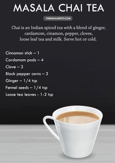 a cup of coffee sitting on top of a table next to a blackboard with information about masala chai tea