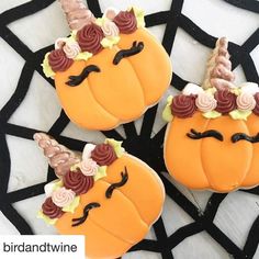 three decorated pumpkins sitting on top of a table