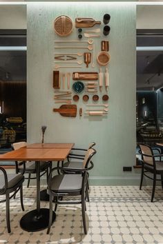 the wall is made up of various kitchen utensils and spoons on it