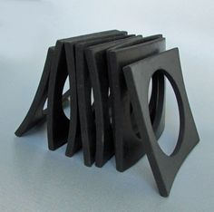 several pieces of black plastic sitting on top of a white table next to each other