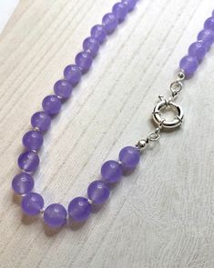 Lavender purple agate beads are hand knotted on white silk. This necklace is finished with silver plate spring clasp. Necklace length is approximately 18.5 inches. Elegant Purple Agate Beaded Necklaces, Purple Agate Gemstone Beaded Necklace, Elegant Purple Agate Beaded Necklace, Knotted Necklace, Purple Agate, Clasp Necklace, Knot Necklace, Lavender Purple, Opal Necklace