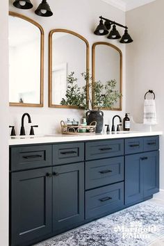 a bathroom with double sinks and mirrors on the wall next to two mirrors above them