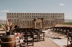 an outdoor ceremony setup with wooden chairs and flowers