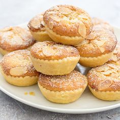 a white plate topped with mini pies covered in powdered sugar