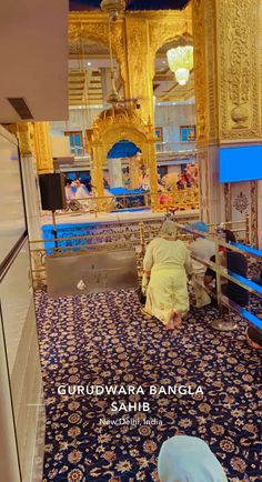 the inside of a building with blue carpet and gold decorations on it's walls