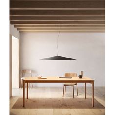 a table with two chairs and a lamp hanging from it's ceiling in an empty room