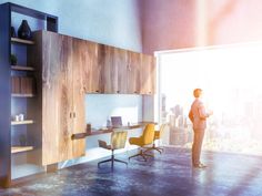 a man standing in an office looking out the window at cityscape and skyscrapers