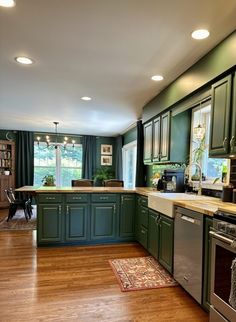 a kitchen with green cabinets and wood floors