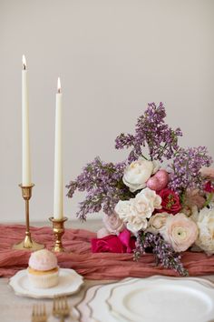 the table is set with flowers and candles