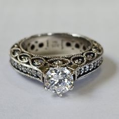 an antique style diamond engagement ring with filigrees