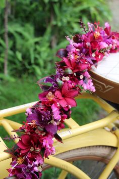 a yellow bicycle with purple flowers on the handlebars