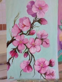 a painting of pink flowers on a blue background next to a bathtub and toilet