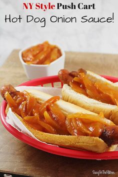 two hot dogs on buns with onions and ketchup in a red plate