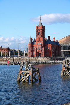 a large building with a clock tower next to the water