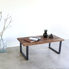 a wooden table with two vases on it