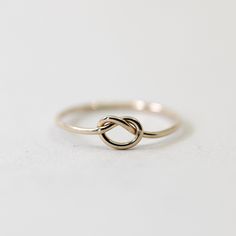 Love knot rings have a deep history throughout the ages and throughout various parts of the world. This dainty ring is a simplified version and features a minimalist knot, perfect for stacking or to be worn on its own.  Made from 14/20 gold-filled wire, it is water-resistant and will be a piece that lasts. Each piece is custom-made for you, so please allow 1-5 days for the jewelry to ship. - 14/20 Gold Filled  - 1.1mm band - Handmade to order - Comes neatly packaged in a kraft jewelry box ready Knot Rings, Dainty Promise Ring, Gold Knot Ring, Love Knot Ring, Zierlicher Ring, Back Jewelry, Knot Ring, Gold Filled Ring, Love Knot