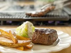 a white plate topped with steak and french fries