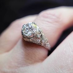 a close up of a person's hand with a diamond ring on their finger