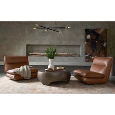 a living room with two leather chairs and a coffee table in front of a fireplace