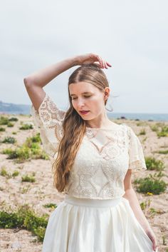 "The 'Ava' top This top is handmade to order in a beautiful cream cotton lace fabric. It has a high scooped neckline at the front and delicate floaty sleeves. The back finishes with a V and rouleaux loops and little covered buttons. This top is individually made to order in sizes XXS - XXL, please refer to size chart below. It can also be made to custom sizes/lengths. For sizing advice or to submit your measurements, please get in touch. It is available in off-white or cream (as pictured). Made from 95% cotton, 5% nylon lace made in England, This top is made to order, designed, cut and stitched by me in England. Please allow 3-4 weeks for making this and depending on where you live 1 week for postage (1 - 2 days for UK). This top is individually made to order in sizes XXS - XXL, please ref Cotton Wedding Dresses, Bridal Dressing Gown, Cotton Lace Tops, Cotton Lace Fabric, Linen Wedding Dress, Cotton Voile Dress, Cream Lace Top, Bridal Skirts, Lace Bolero