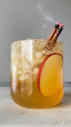 an apple cider with two cinnamon sticks sticking out of it