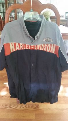 an old harley davidson jacket is hanging on a chair in a room with wooden floors