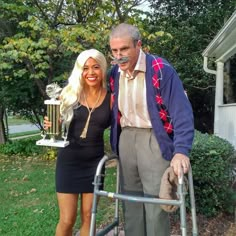 a man standing next to a woman holding a trophy