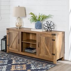 a wooden sideboard with sliding doors on top and a lamp next to it in a living room