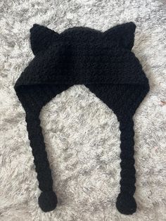 a black cat hat laying on top of a white carpet