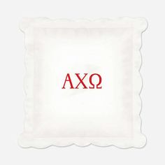 the word axq is written in red on a white square pillow with scalloped edges