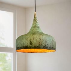 a green light hanging from a ceiling in a room