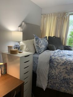 a bed sitting under a window next to a night stand