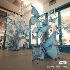 several blue butterflies are flying in the air near two windows with glass panes behind them