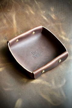 a brown leather tray sitting on top of a table