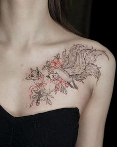 a woman with a tattoo on her chest has flowers and a fox in the background