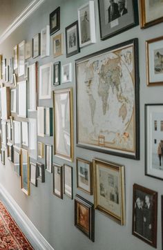 a wall with many framed pictures on it