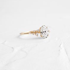 an oval diamond ring with two small diamonds on the side