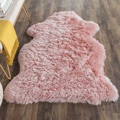 a pink rug is on the floor next to a yellow chair