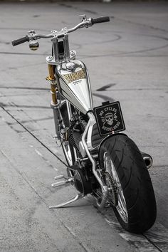 a motorcycle parked on top of a parking lot next to a sidewalk with no people