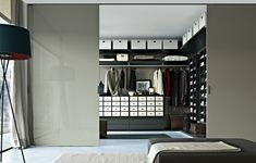 a walk in closet with lots of clothes on shelves