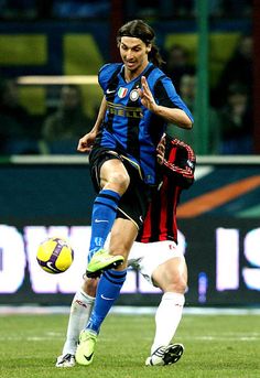 a man kicking a soccer ball on top of a field