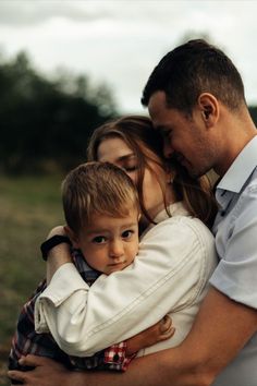 a man and woman holding a child in their arms