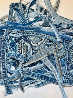 a pile of blue jeans sitting on top of a white table next to each other