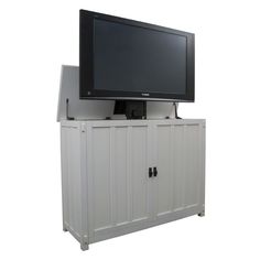 a flat screen tv mounted on top of a white cabinet