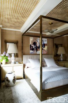 a bedroom with a four poster bed and two lamps